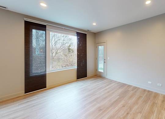 A room with wooden floors and a large window.