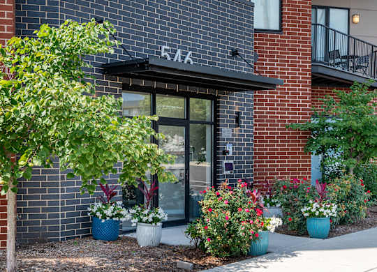 A red brick building with a black awning and a glass door.