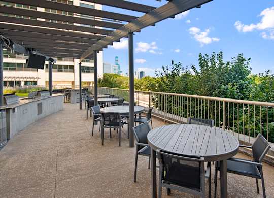 A patio with a table and chairs overlooking a cityscape.