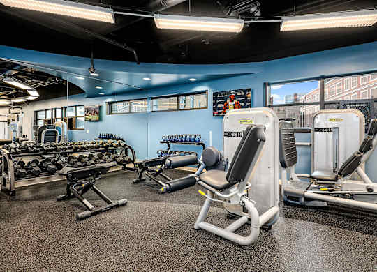 A gym with a variety of equipment including weights and machines.