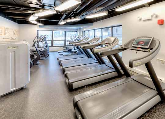 A gym with treadmills and elliptical machines.