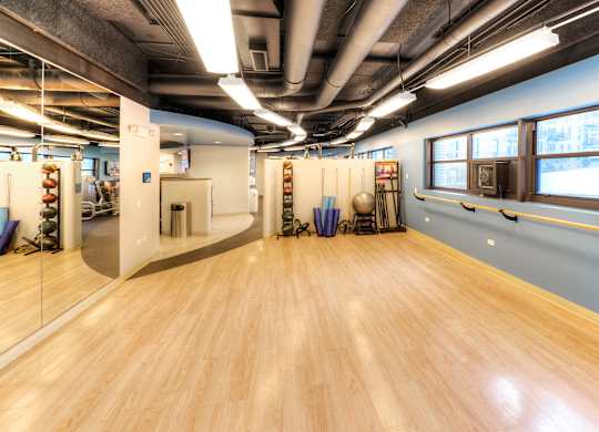 A room with wooden floors and mirrors on the wall.