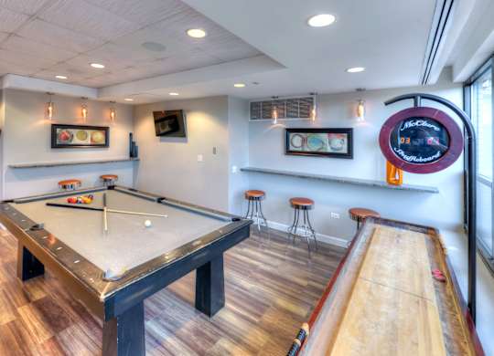 A pool table with a white cloth and a pool cue on it.