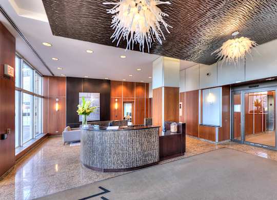 A reception area with a wooden counter and a chandelier hanging from the ceiling.