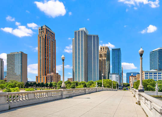 A cityscape with a bridge in the foreground and tall buildings in the background.