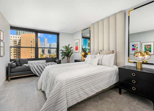 A bedroom with a large bed and a view of the city.