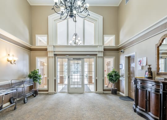 a large hallway with a chandelier and a glass door