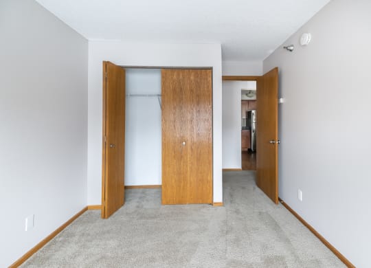 an open door leads into an empty room with a carpeted floor