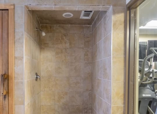 a large walk in shower with a water heater on the floor