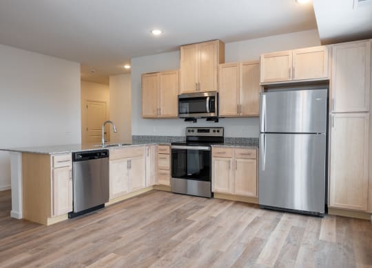 an empty kitchen with wooden cabinets and stainless steel appliances