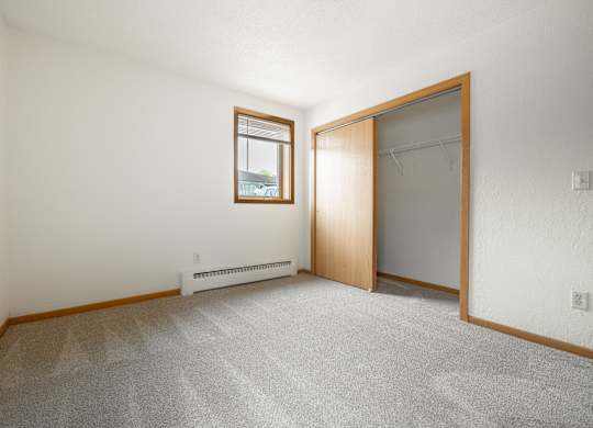 an empty room with a closet and a window at Ames Lake Neighborhood Apartments, St. Paul, 55106