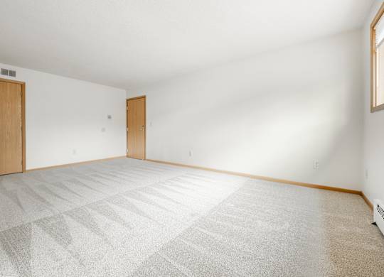 the living room of a house with a white floor and a wooden door at Ames Lake Neighborhood Apartments, St. Paul, 55106
