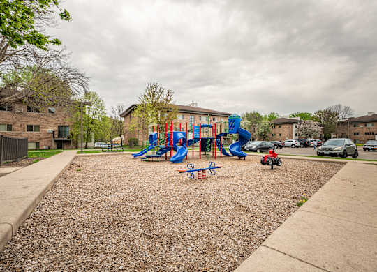 a playground in a park in front of a building at Ames Lake Neighborhood Apartments, Minnesota