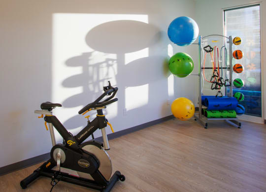 a gym with an exercise bike and balloons on the wall