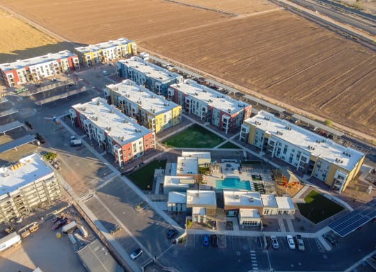 an aerial view of apartment buildings and a field