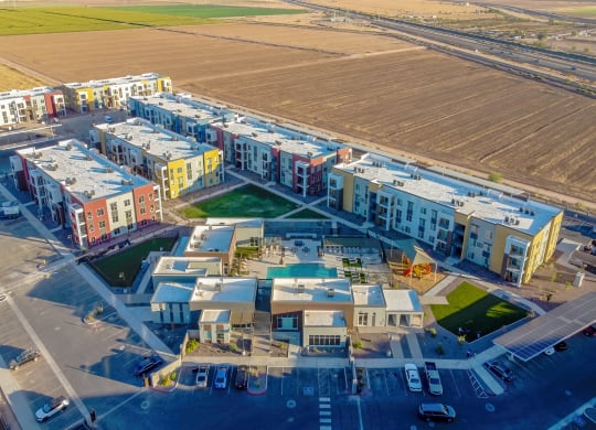 an aerial view of a group of apartment buildings with a field