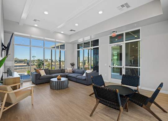 A living room with a grey couch, a black chair and a wooden table at Copa Flats Apartments, Arizona, 85138