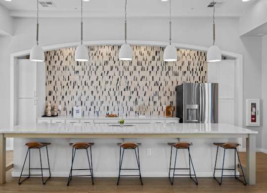 A kitchen with a white counter and bar stools at Copa Flats Apartments, Maricopa, Arizona
