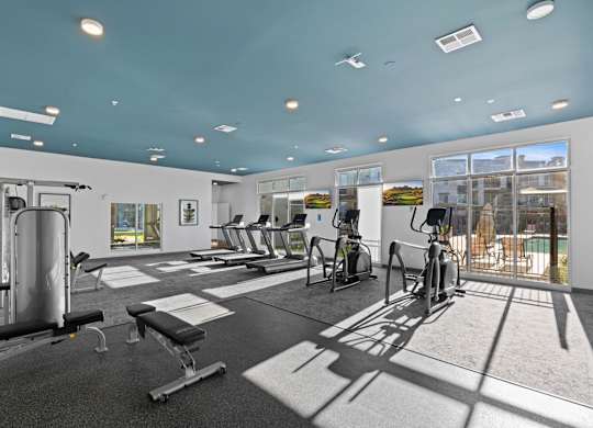 A gym with a variety of equipment including treadmills, weights, and exercise bikes at Copa Flats Apartments, Maricopa, 85138