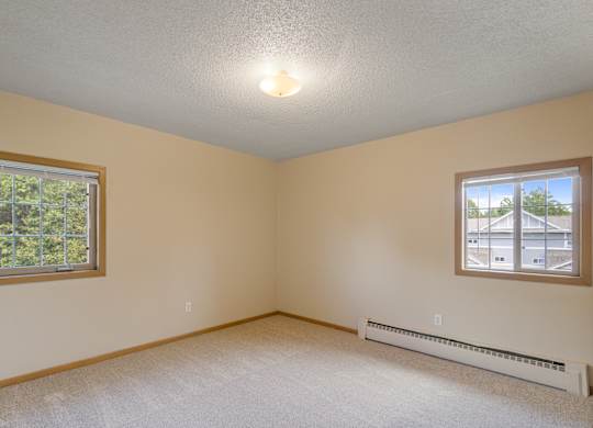 A room with a window and a wall-mounted air conditioner.