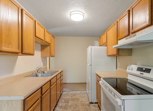 A kitchen with wooden cabinets and white appliances.