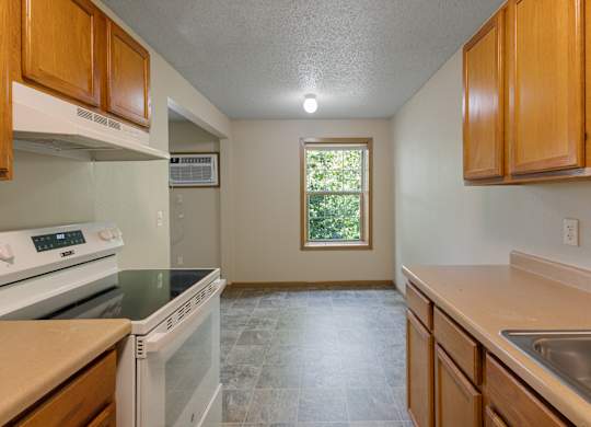 A kitchen with a white oven and a window.