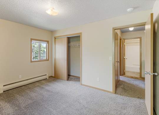 A room with a carpeted floor and a window.