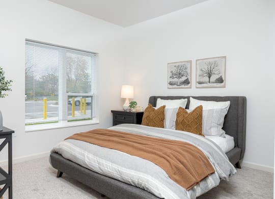 a bedroom with a bed and two windows