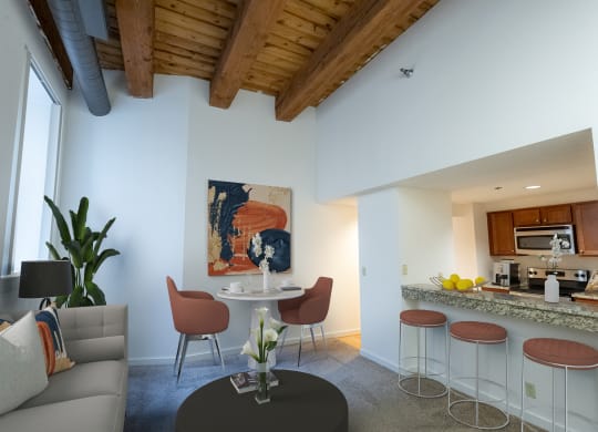 a living room with a kitchen and a table with four chairs