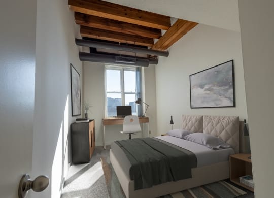 a bedroom with a bed and a desk and a window