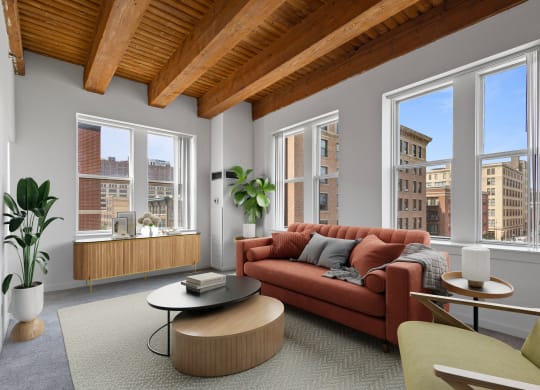 a living room with a red couch and a large window