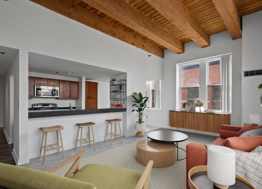 a living room with a couch and a kitchen with a counter and a window