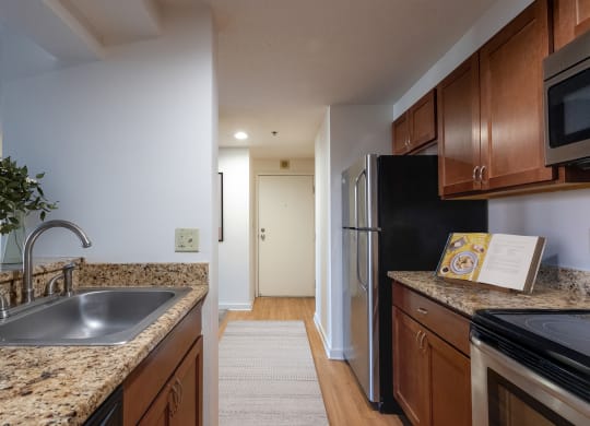 a kitchen with granite counter tops and a stainless steel refrigerator