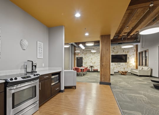 a kitchen and living room with a stove and a tv