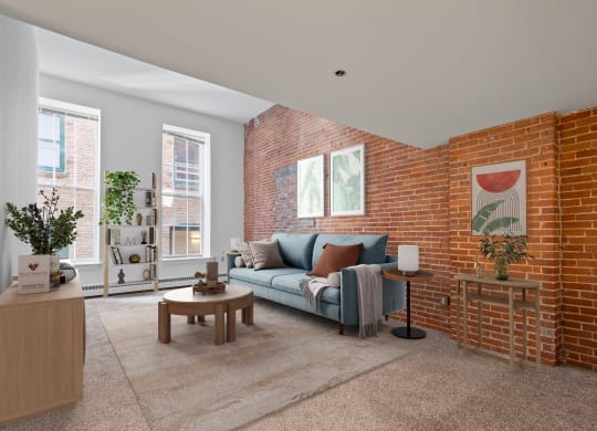 a living room with a couch and a brick wall