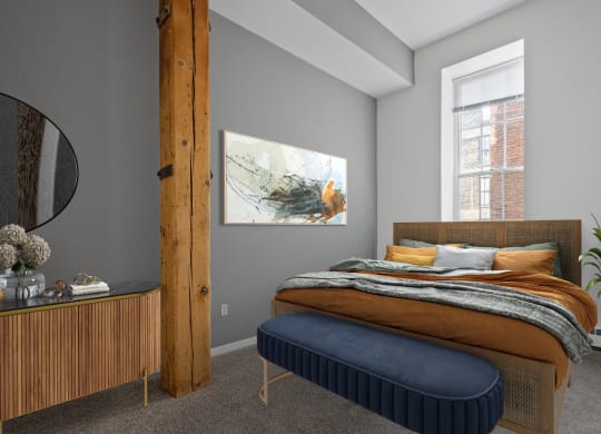 a bedroom with a bed and a blue ottoman
