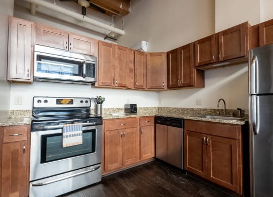 an empty kitchen with wooden cabinets and stainless steel appliances