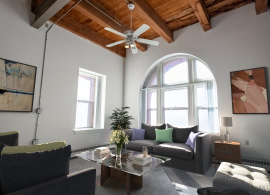 a living room with a ceiling fan and a large window