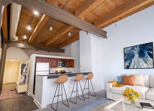 a kitchen with a bar and a living room with a couch