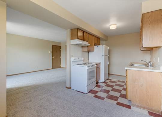 A kitchen with a white fridge and a checkered floor.