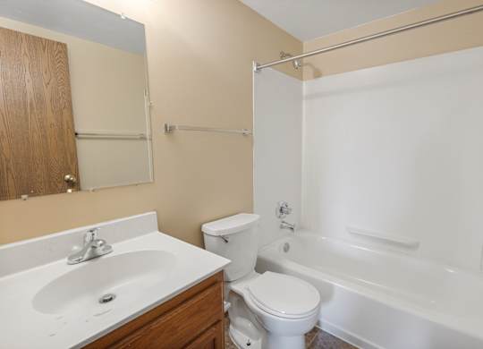 A white toilet sits next to a white sink in a bathroom.