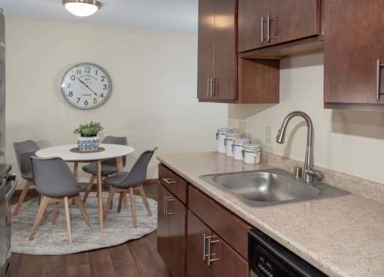 a kitchen with a sink and a table with chairs