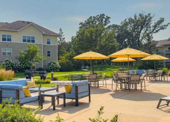 an outdoor patio with tables and chairs and umbrellas