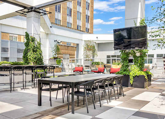 A patio with a table and chairs is surrounded by buildings.