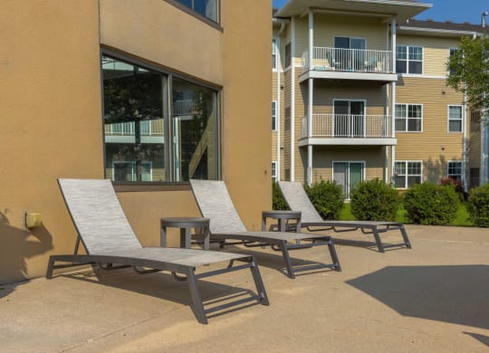 a patio with two chairs and a table in front of a building