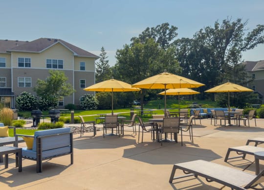 an outdoor patio with tables and chairs and umbrellas