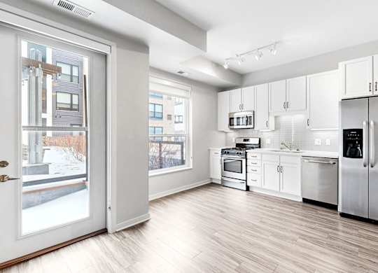 A modern kitchen with stainless steel appliances and white cabinetry.