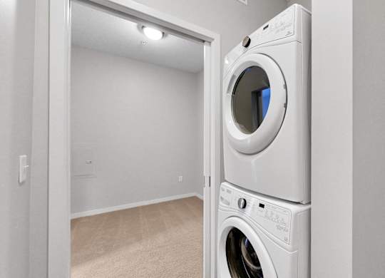 A white washing machine is in a small room.