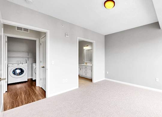 A laundry room with a washer and dryer is visible from the open door.