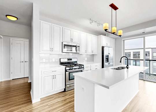 A modern kitchen with white cabinets and a large island.